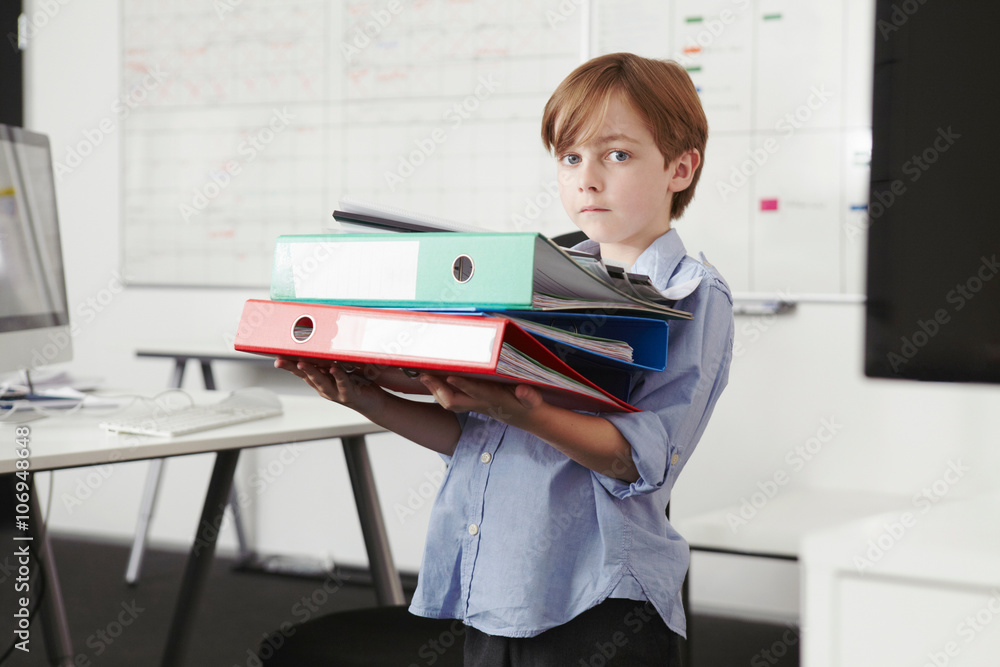 Boy holding pile of ring binders Stock Photo | Adobe Stock