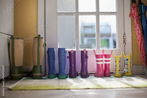 Tidy row of rubber boots at back door photo