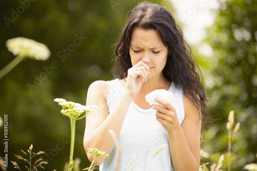 Girl with tissue rubbing nose photo