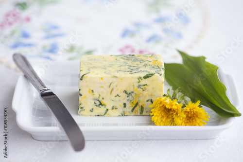 Wild garlic (Allium ursinum) butter with dandelion flower and leaves on butterdish photo