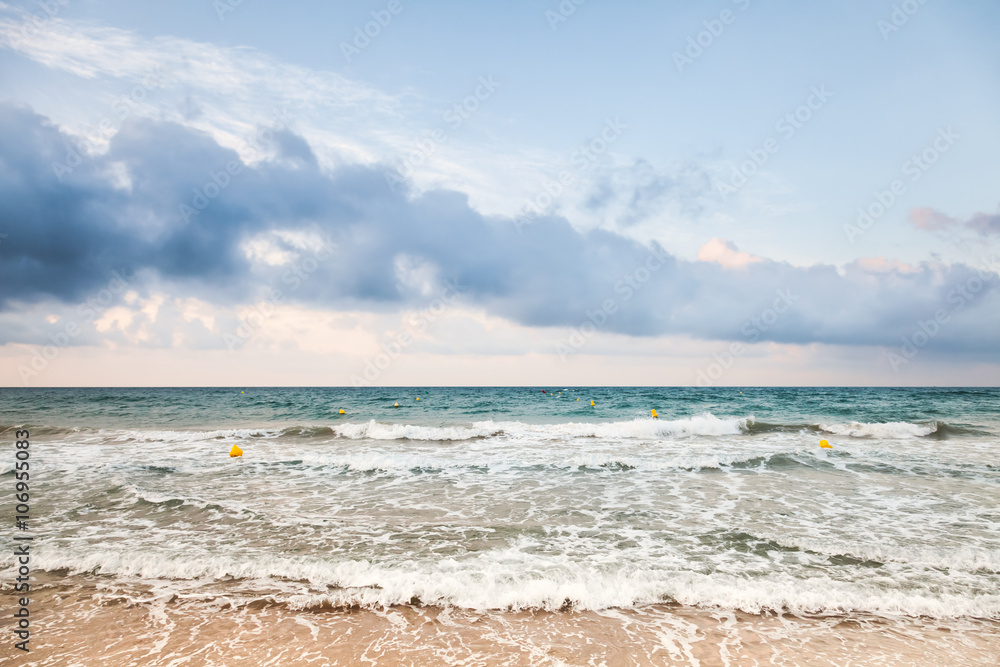 Surf on sandy Mediterranean beach at morning