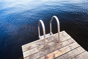Fotobehang Pier Diepblauw water bij houten zwemsteiger  © evannovostro
