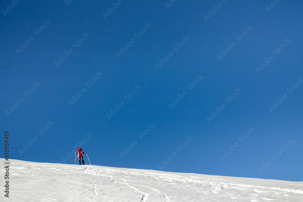 One climber tourist on a mountain slope in winter with copy spac