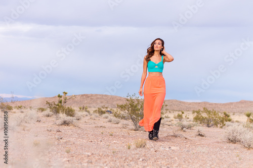 Attractive fashionable young woman in the desert walking in pink skirt © BestStockFoto