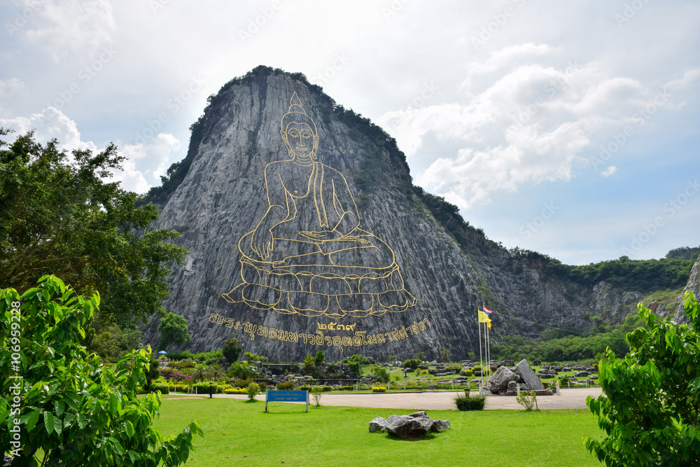 Fototapeta premium Golden Buddha laser carved on Khao Chee Chan, Sattahip, Chonburi