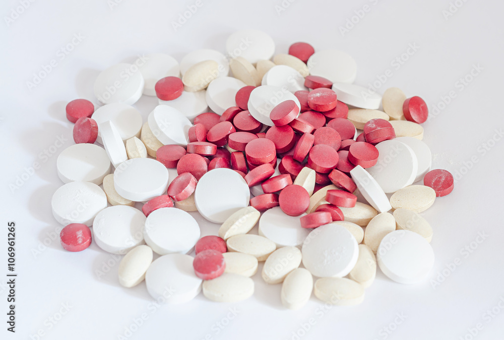 Red, white and yellow drugs pills, powder, bunch, medical, homeopathic, white background, close up