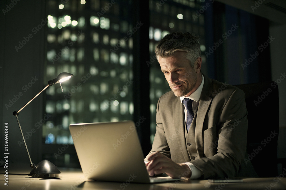 Businessman working late in office on laptop Businessman working late in office on laptop