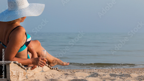 Beautiful woman drinking wine and sunbathing