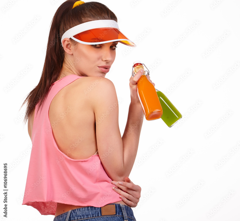 Smiling pretty young fitness woman in pink top holding half of b Smiling pretty young fitness woman in pink top holding half of b