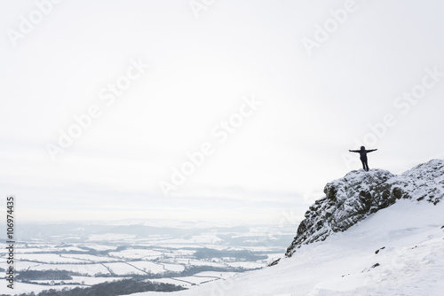 Woman standing on The Wrekin in winter, Shropshire, England, UK photo