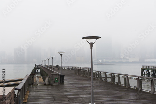 East river pier and skyline in mist, New York City, USA