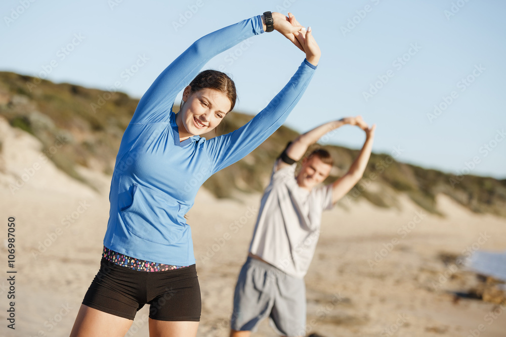 Fototapeta premium Young couple on beach training together