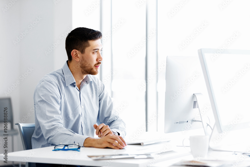 Fototapeta premium Male office worker sitting at desk