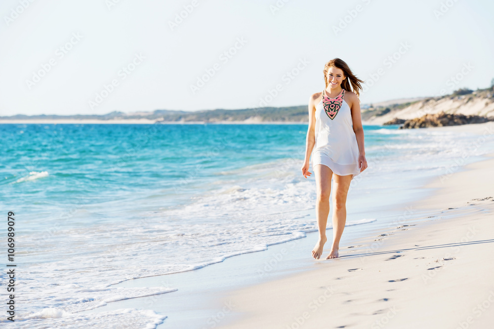 Young woman walking along the beach Young woman walking along the beach
