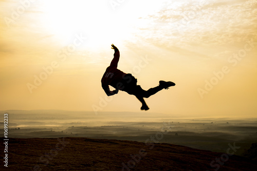 young man is jumping on top of the mountain