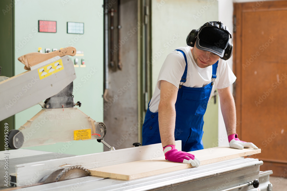 worker in workshop using saw machine worker in workshop using saw machine