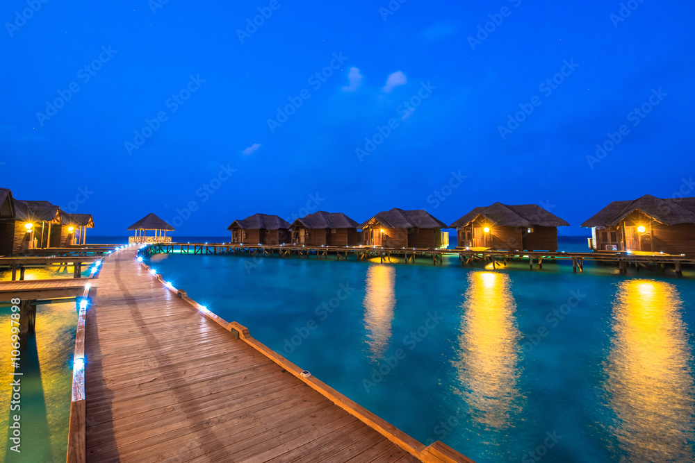 Fototapeta premium Over water bungalows with steps into amazing green lagoon 
