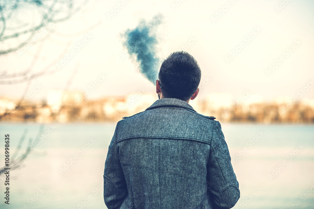 Fototapeta premium Man with beard vaping outdoor electronic sigarette