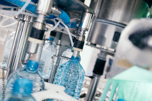 Robotic factory line for processing and bottling of pure spring water into canisters and bottles. Selective focus.