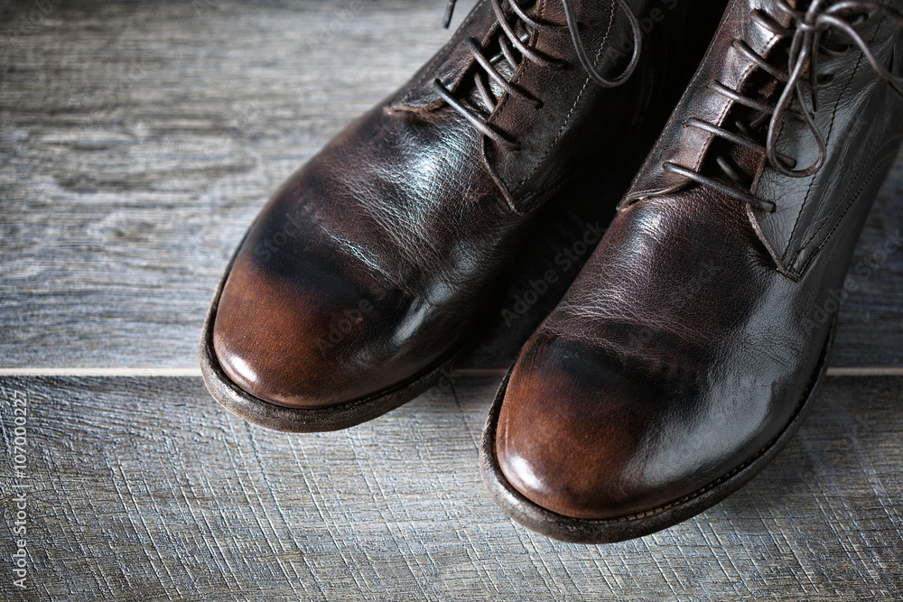 brown leather shoes on a wooden surface. beautiful boots in a grunge style, top view