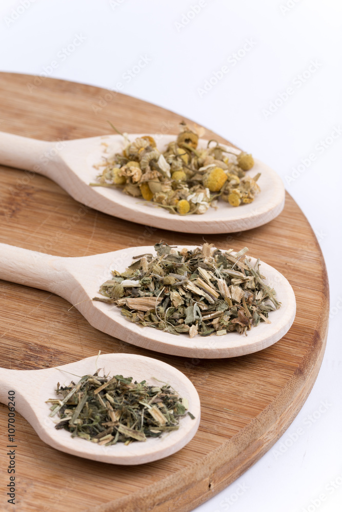 Chamomile nettle and basil tea on a wooden spoon Chamomile nettle and basil tea on a wooden spoon