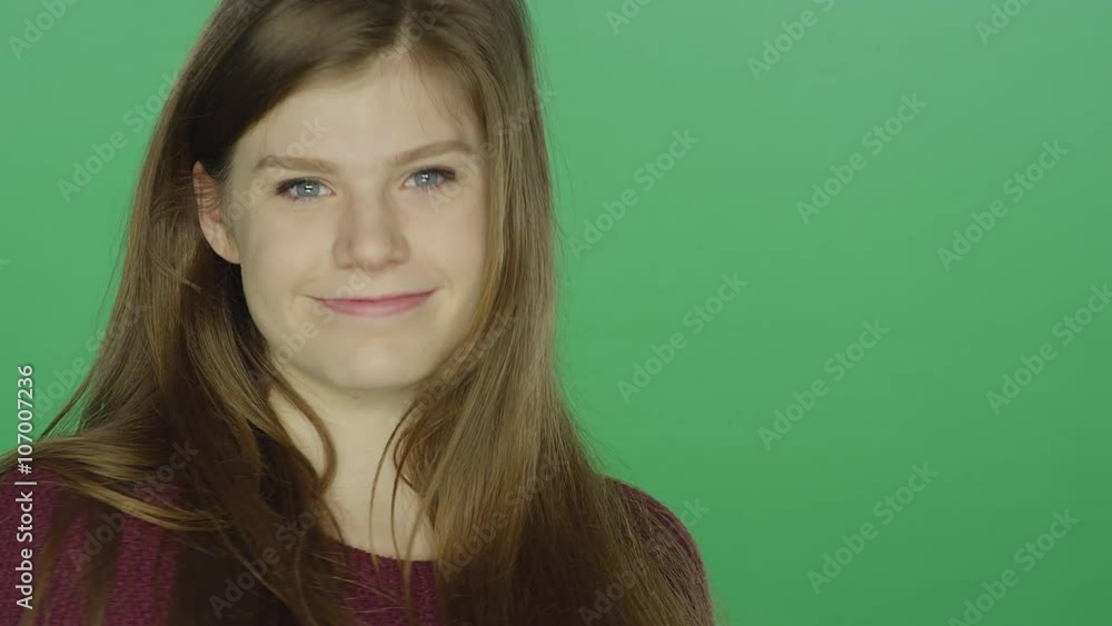 Young brunette woman posing and smiling, on a green screen studio background Young brunette woman posing and smiling, on a green screen studio background