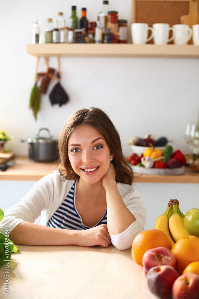 Young woman sitting near desk in the kitchen