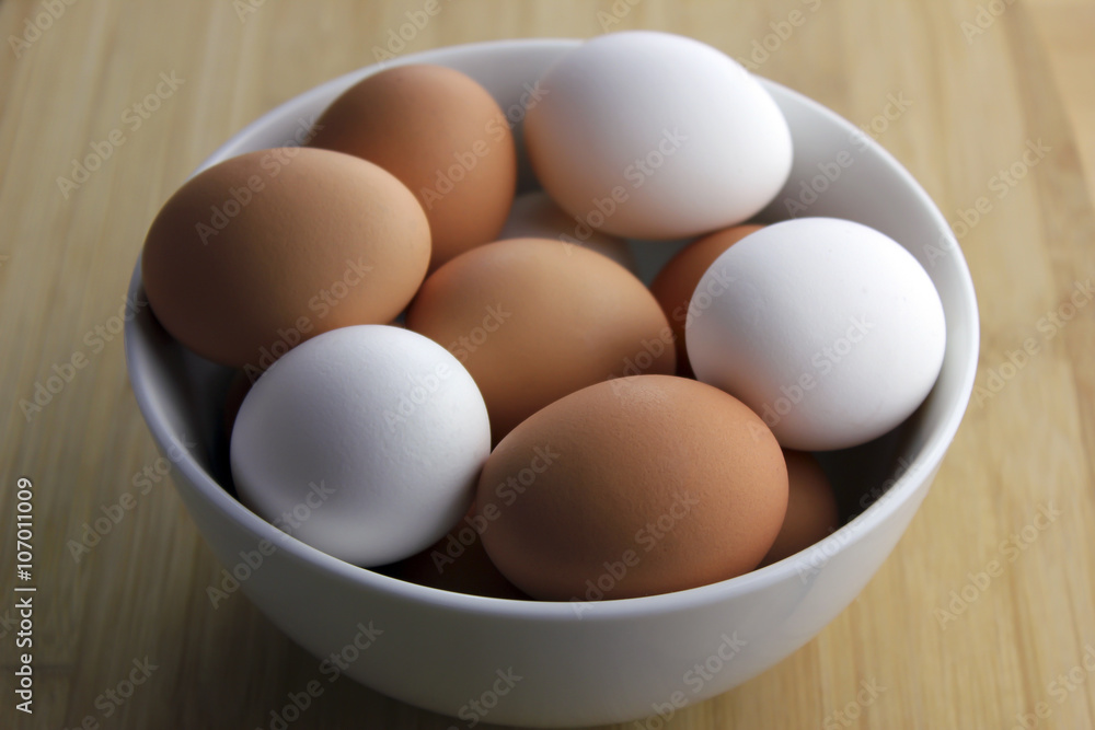 A bowl of a mix of fresh brown and white eggs A bowl of a mix of fresh brown and white eggs