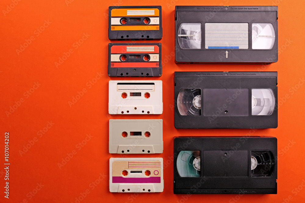 Set of old audio and video cassettes on red background