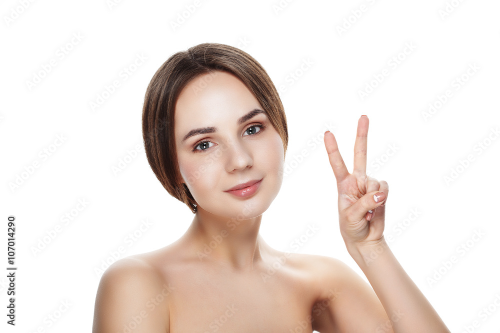 Pretty girl with natural makeup show gesture VICTORY. Beautiful spa woman touching her face. Perfect fresh skin. Pure beauty model girl. Youth and skin care concept Pretty girl with natural makeup show gesture VICTORY. Beautiful spa woman touching her face. Perfect fresh skin. Pure beauty model girl. Youth and skin care concept