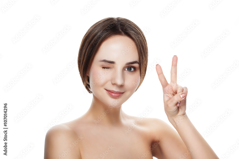 Pretty girl with natural makeup show gesture VICTORY. Beautiful spa woman touching her face. Perfect fresh skin. Pure beauty model girl. Youth and skin care concept Pretty girl with natural makeup show gesture VICTORY. Beautiful spa woman touching her face. Perfect fresh skin. Pure beauty model girl. Youth and skin care concept