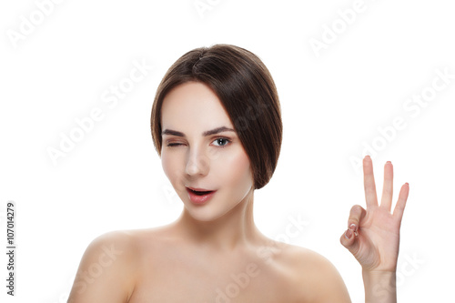 Pretty girl with natural makeup show gesture OKEY. Beautiful spa woman touching her face. Perfect fresh skin. Pure beauty model girl. Youth and skin care concept