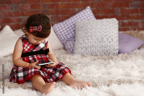 Little girl watching smartp...