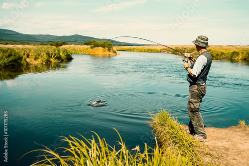 Middle aged man fishes caught pink salmon from the river