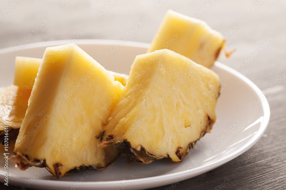 Pineapple pieces on a white ceramic plate Pineapple pieces on a white ceramic plate