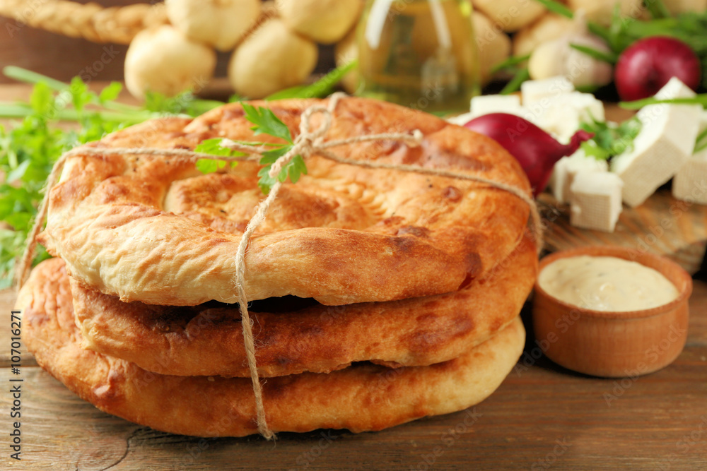Fresh fried bread with other products on wooden table closeup Fresh fried bread with other products on wooden table closeup