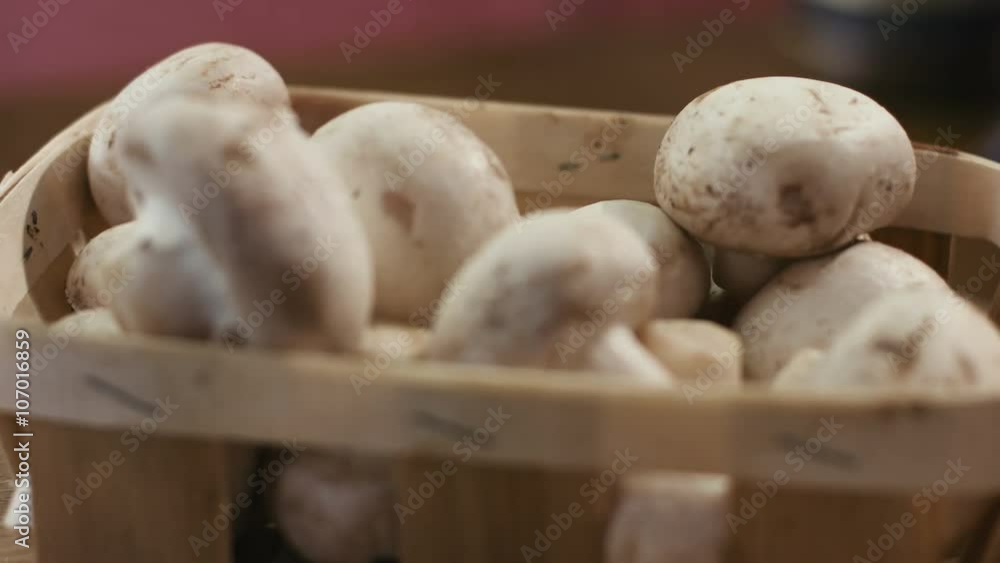 Basket full of champignon mushrooms isolated on a wooden background. Basket full of champignon mushrooms isolated on a wooden background.