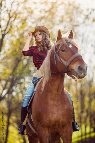 Beautiful girl riding horse on autumn field © Buyanskyy Production