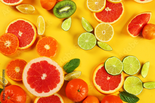 Set of sliced citrus fruit on yellow background