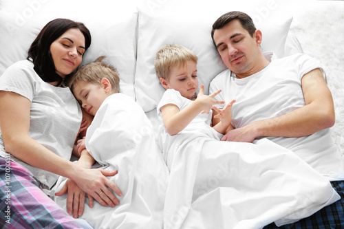 Family sleeping in bed, clo...