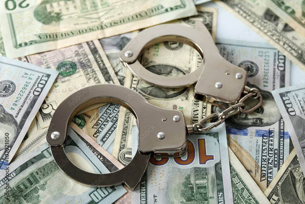 Handcuffs on dollar banknotes. Corruption concept