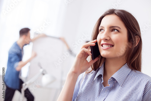Beautiful female worker is using a telephone
