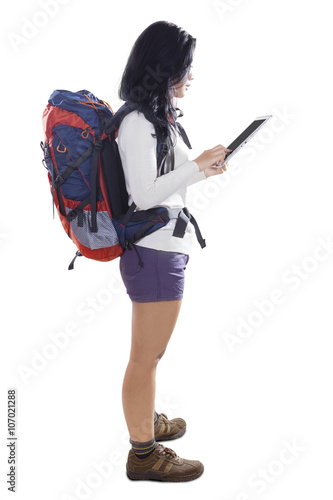 Female backpacker using tablet in studio