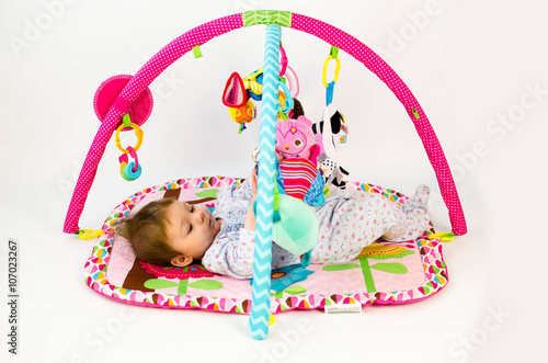 baby girl playing in an activity gym