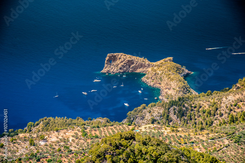 Beautiful landscape picture with rocky mountains and sailboats near the ring-shaped cliff, Mallorca, Spain.