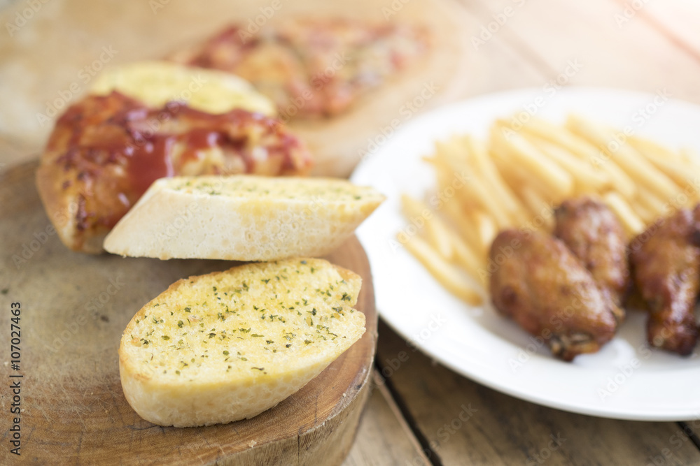 Fast food, crispy chicken wings,bread,french fries and pizza on Fast food, crispy chicken wings,bread,french fries and pizza on