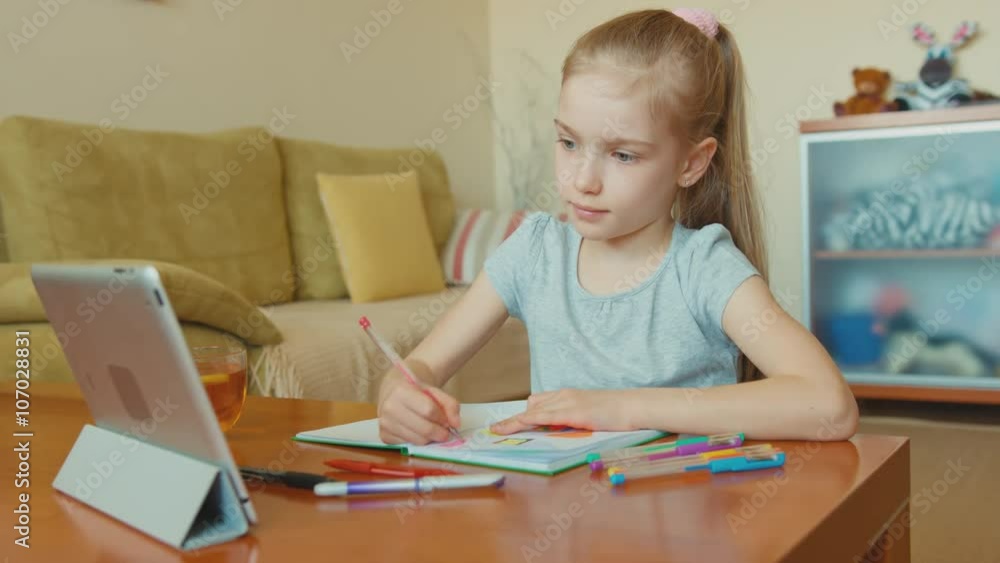 Child drawing in a notebook and looking at camera Child drawing in a notebook and looking at camera