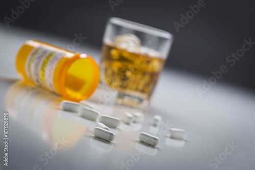 Prescription Drugs Spilled From Fallen Bottle Near Glass of Alco