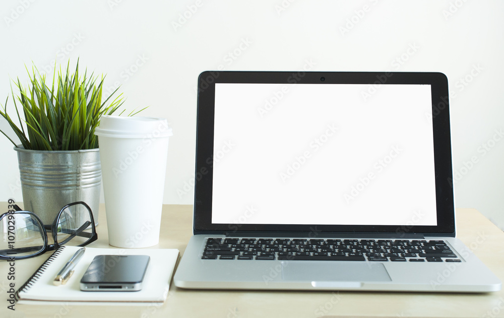 Laptop with smartphone ,blank notebook,calculator and small green plant Laptop with smartphone ,blank notebook,calculator and small green plant