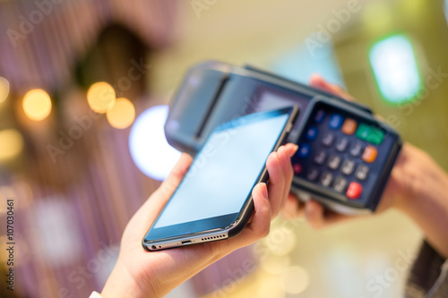 Fototapeta Naklejka Na Ścianę i Meble -  Woman pay with cellphone by NFC technology